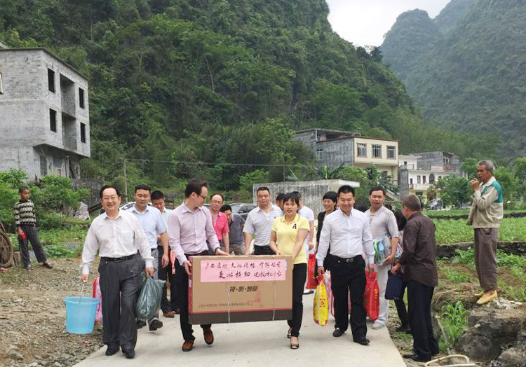 韦昌炳与妻子因生病住院，亲戚代替他们在村口迎接爱心人士