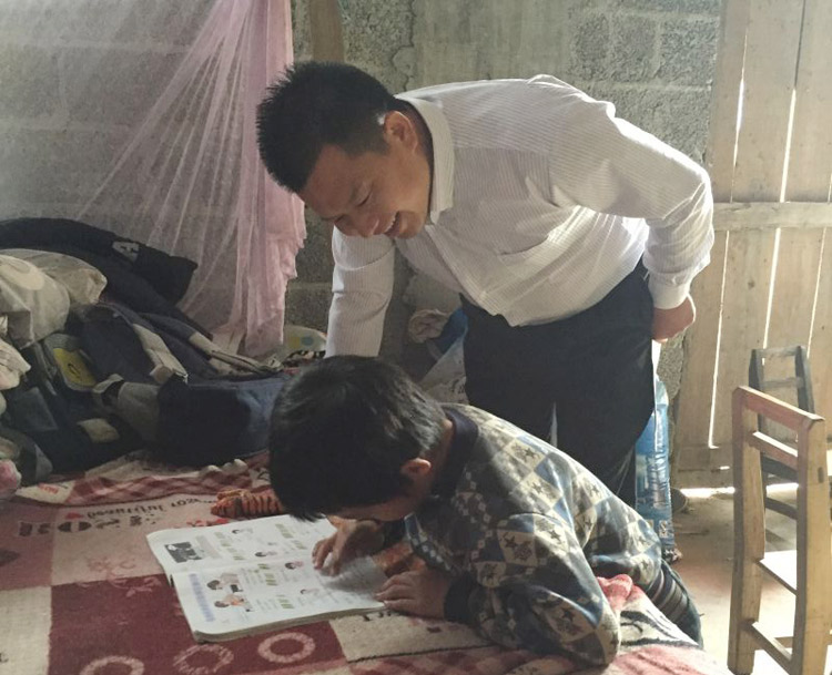 广西农村扶贫助困联合会会长兼广西泰宁集团董事长符安卫询问孩子的学习